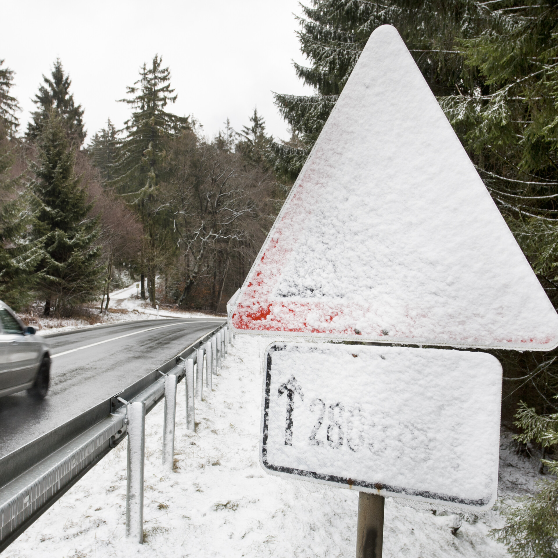 Schnee verdeckt ein Verkehrszeichen