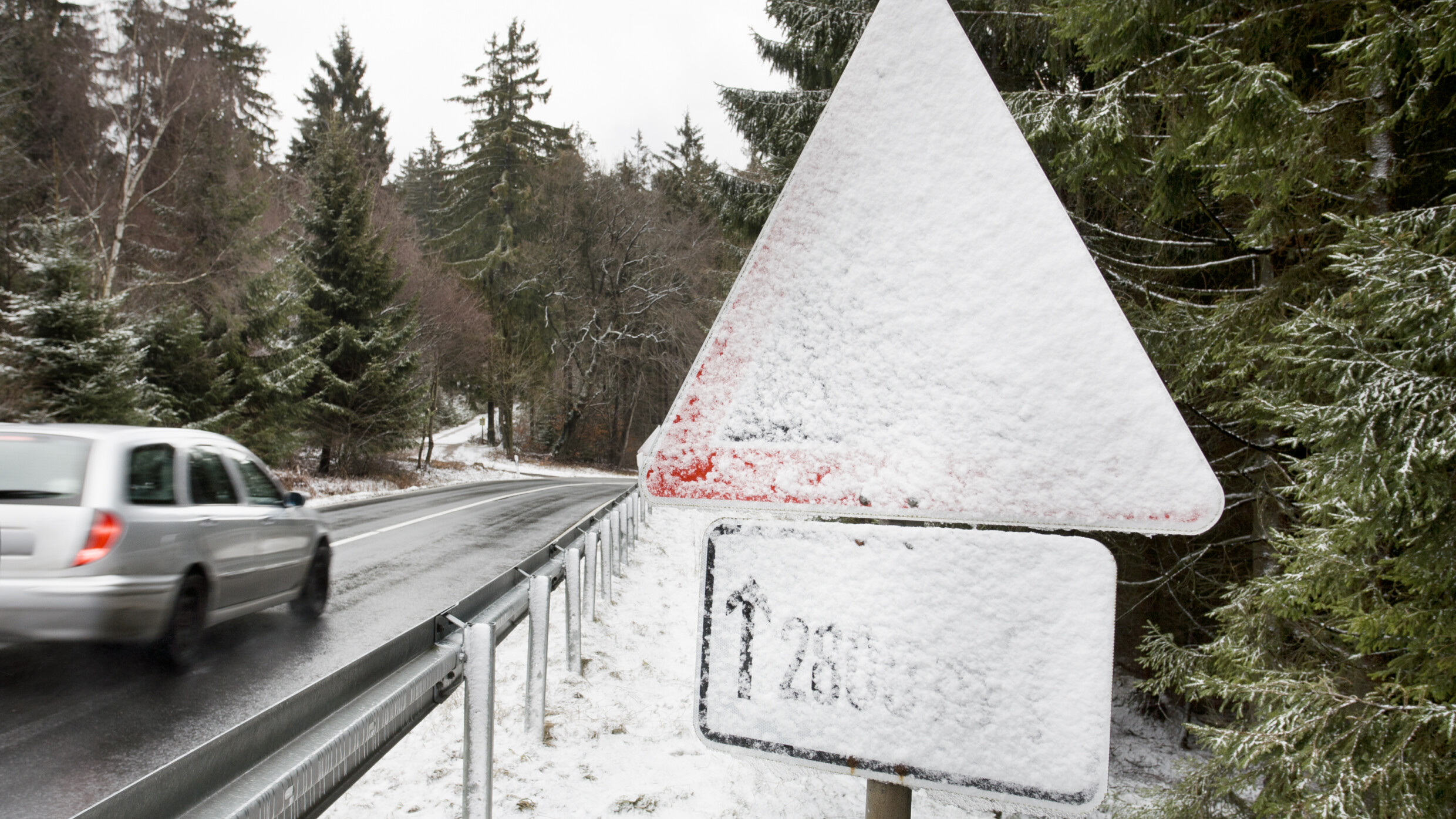 Schnee verdeckt ein Verkehrszeichen