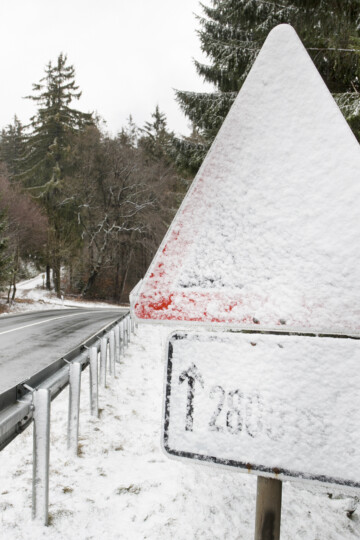 Schnee verdeckt ein Verkehrszeichen